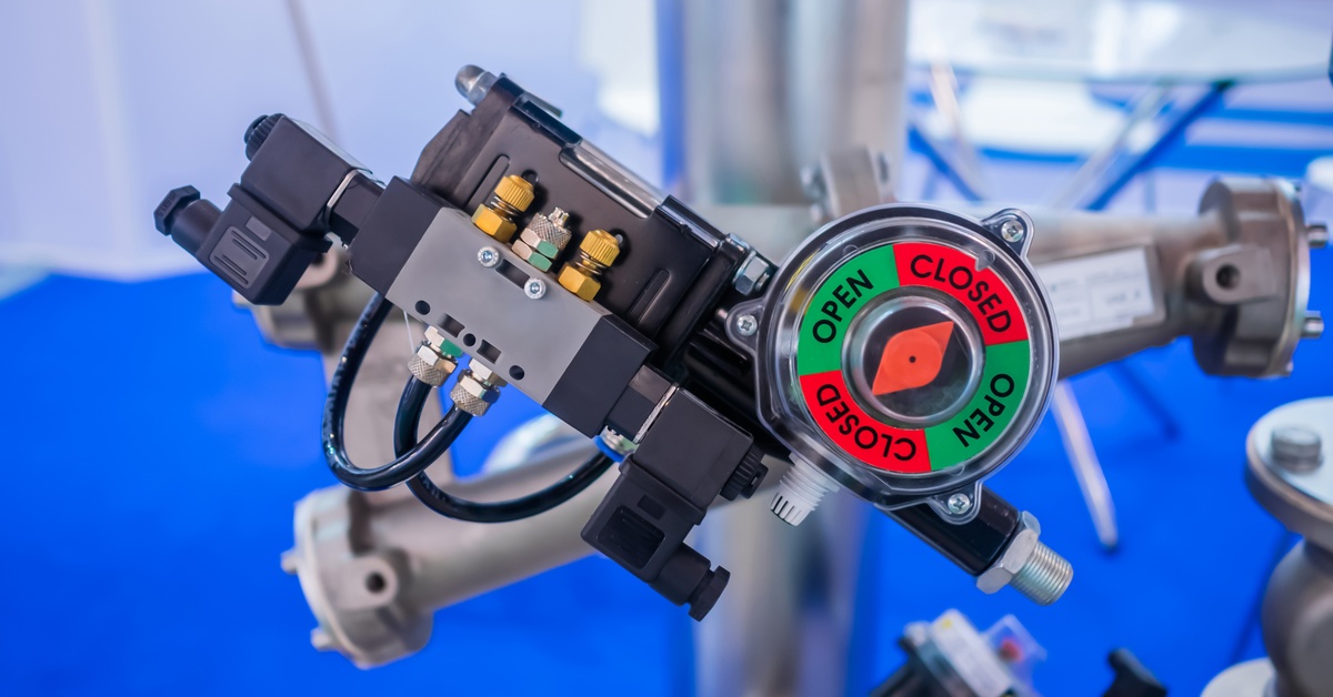 An industrial, high-pressure solenoid valve system with a green-and-red gauge showing whether it’s open or closed.