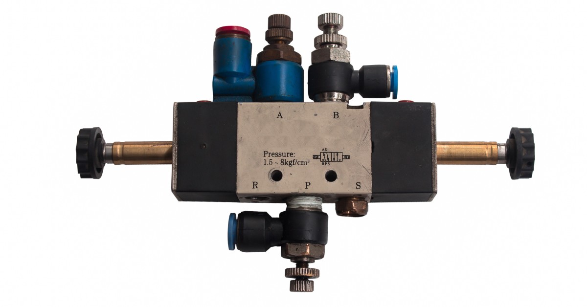 An industrial solenoid valve with connected pipes and insulation displayed against a white background.