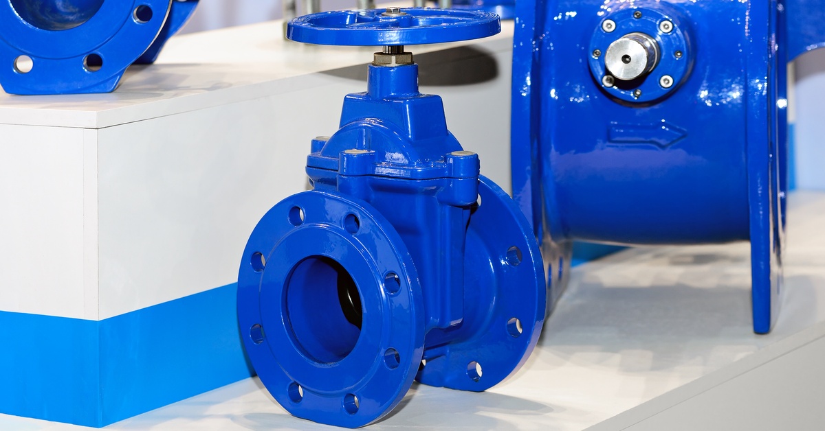 Two blue industrial rotary valves connected to a piping system, displayed in a clean industrial setting.